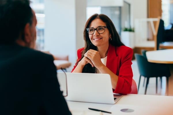 Two colleagues having a professional conversation in a workplace setting
